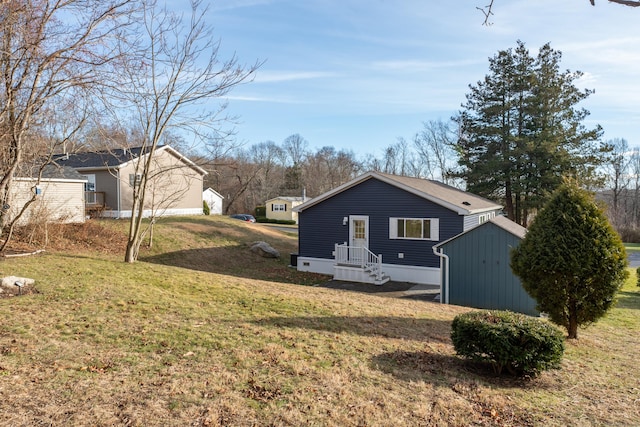 view of side of property with a yard and a storage unit