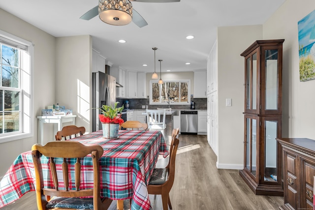 dining area featuring ceiling fan and light wood-type flooring