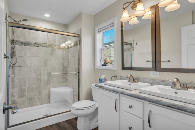 bathroom with walk in shower, vanity, toilet, and hardwood / wood-style floors