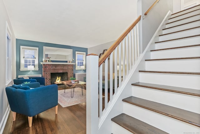 staircase featuring hardwood / wood-style flooring and a fireplace