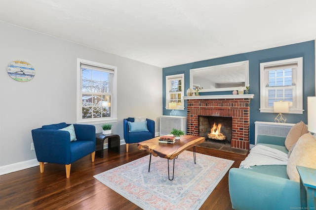 living room featuring dark hardwood / wood-style floors, plenty of natural light, and a brick fireplace