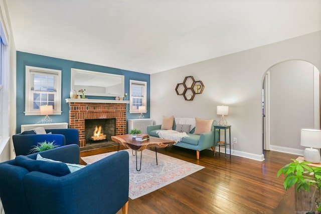 living room featuring a fireplace and dark wood-type flooring