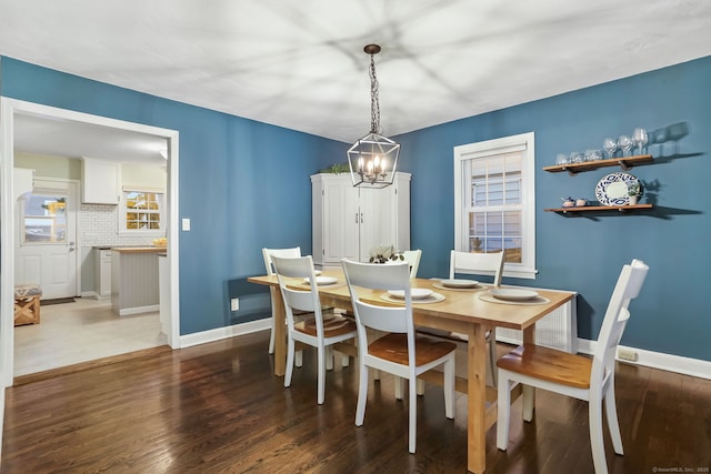 dining space with a notable chandelier and dark hardwood / wood-style floors