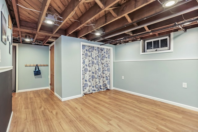 basement with light hardwood / wood-style flooring and wooden ceiling