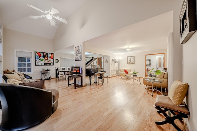 living room featuring high vaulted ceiling, ceiling fan, and light hardwood / wood-style flooring