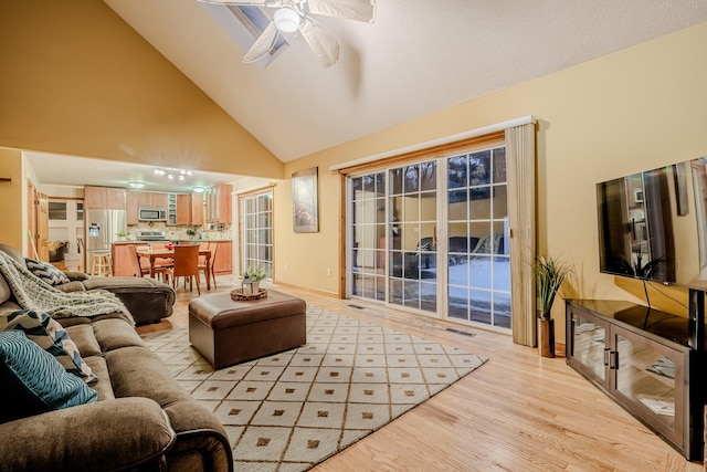 living room featuring light wood-type flooring, high vaulted ceiling, and ceiling fan