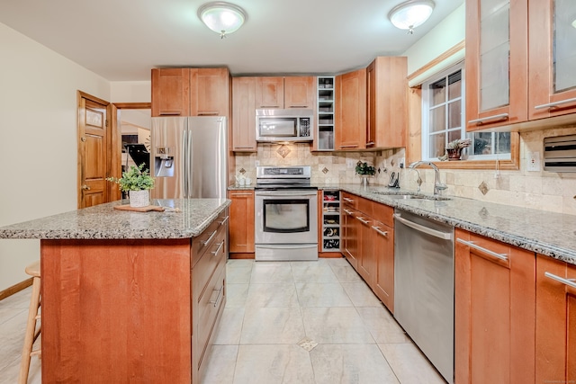 kitchen with sink, a center island, stainless steel appliances, a breakfast bar area, and tasteful backsplash