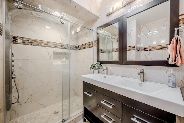 bathroom featuring vanity, an enclosed shower, and tile walls