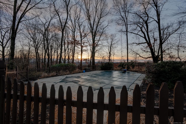 yard at dusk with a covered pool and a patio