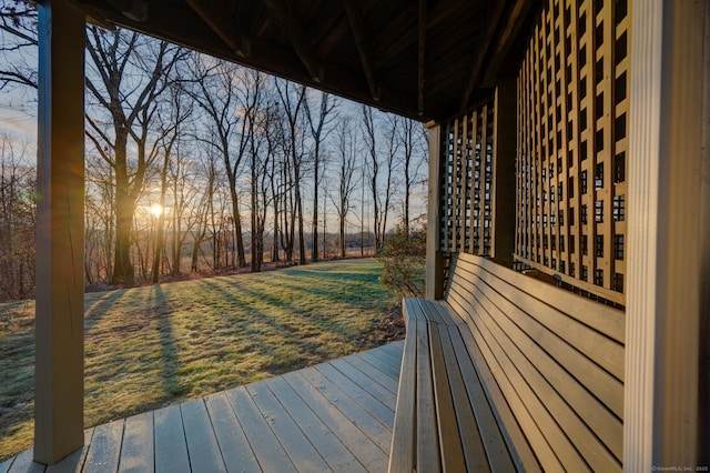 deck at dusk featuring a yard