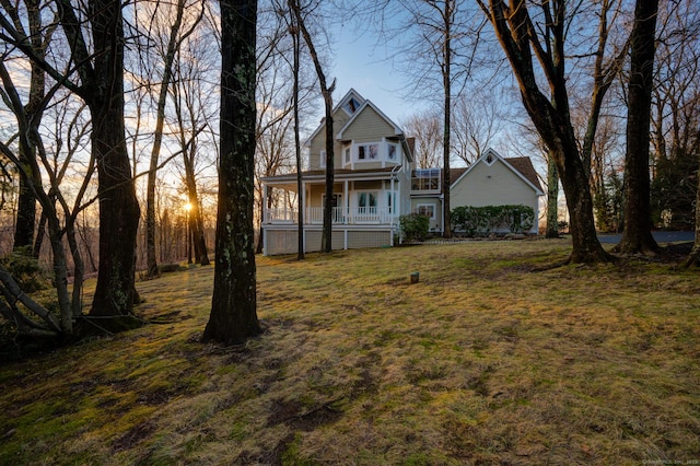 yard at dusk featuring covered porch