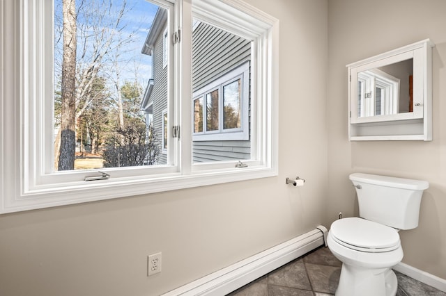 bathroom with a baseboard heating unit, tile patterned floors, toilet, and a healthy amount of sunlight