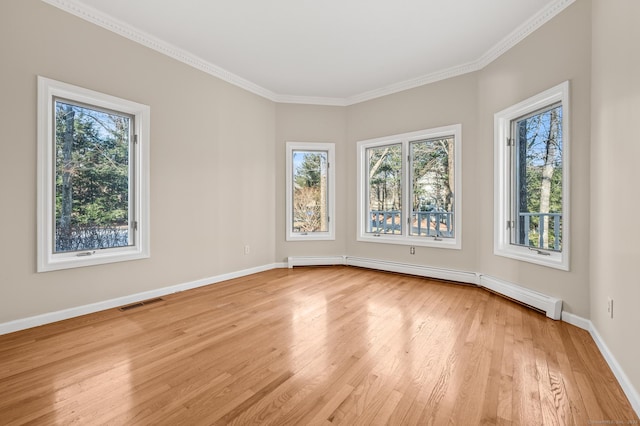 empty room with baseboard heating, plenty of natural light, and light hardwood / wood-style floors