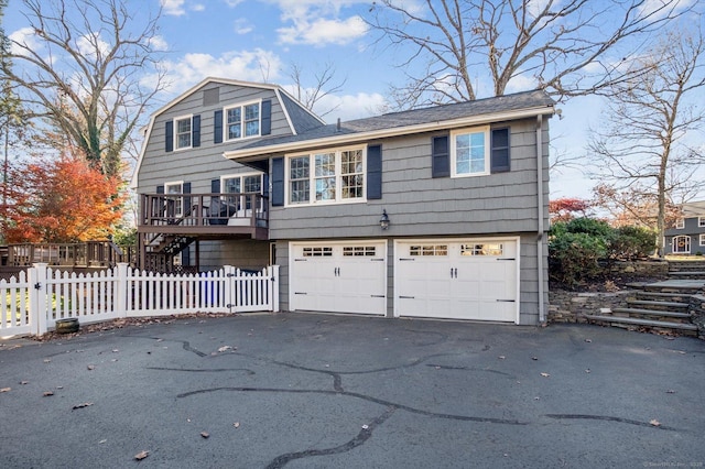 front facade with a wooden deck and a garage