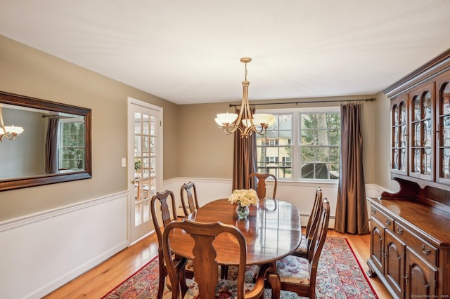 dining space featuring light hardwood / wood-style flooring and a chandelier