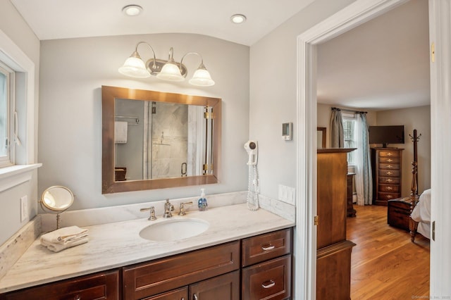 bathroom featuring hardwood / wood-style floors, vanity, and a shower with shower door