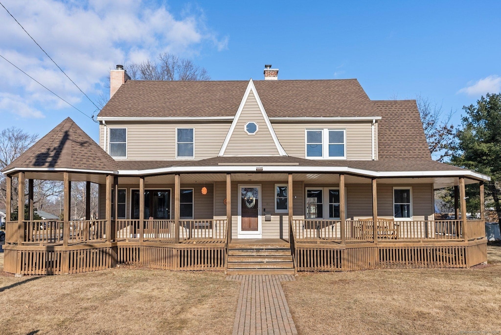 farmhouse with a porch and a front lawn