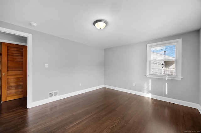 spare room featuring dark wood-type flooring