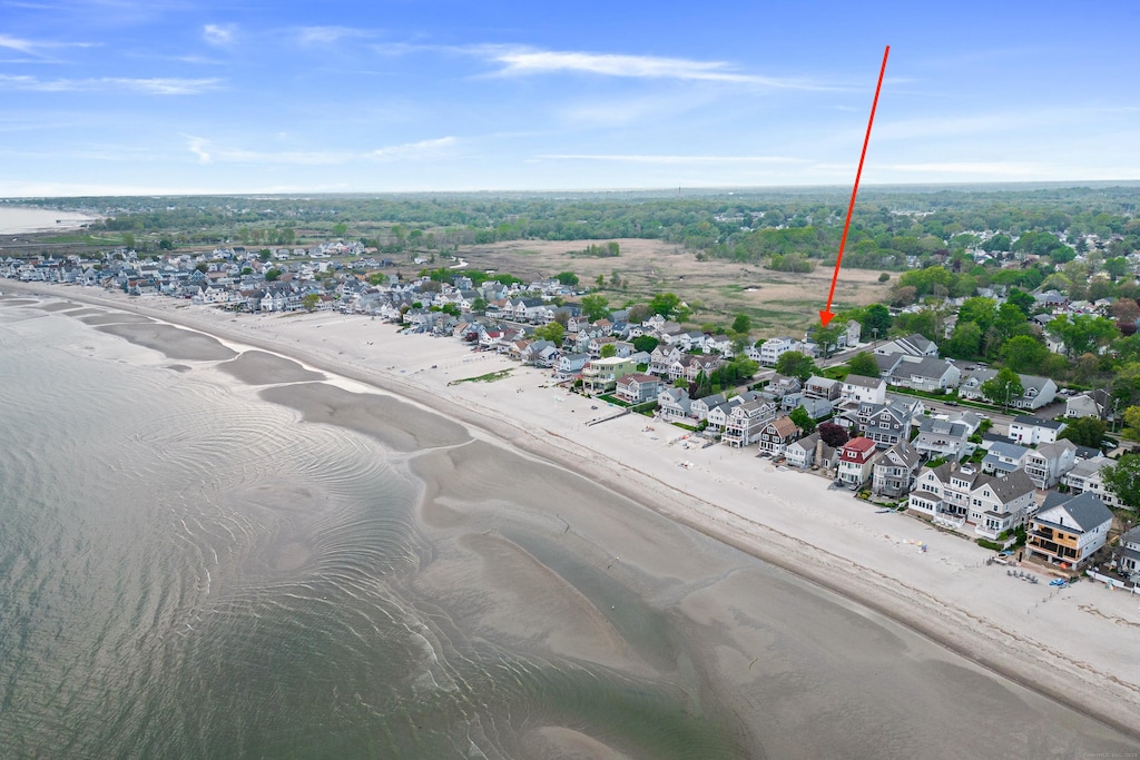 drone / aerial view with a water view and a view of the beach