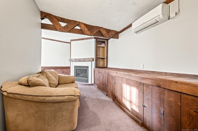 living room featuring light carpet, a fireplace, a textured ceiling, beamed ceiling, and a wall unit AC