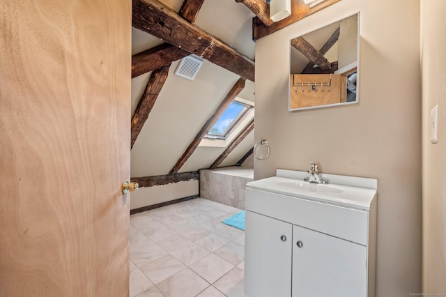 bathroom featuring vanity and vaulted ceiling with skylight