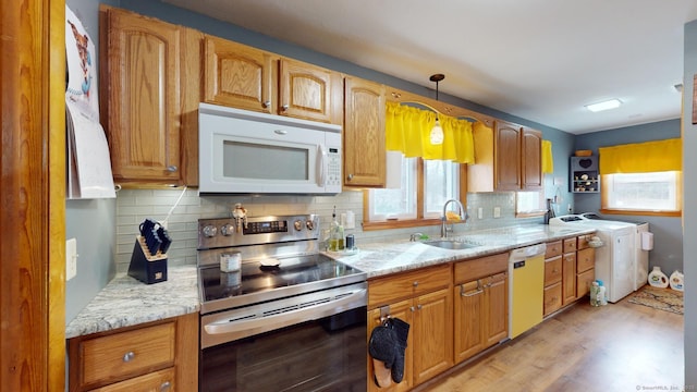 kitchen featuring white appliances, hanging light fixtures, tasteful backsplash, and sink