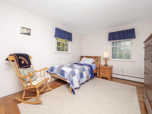 bedroom with a baseboard radiator and hardwood / wood-style floors