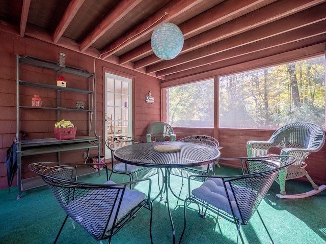 sunroom / solarium featuring beamed ceiling