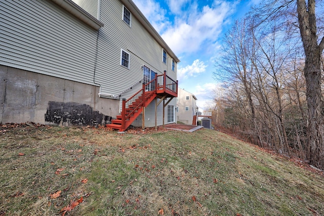 view of side of home featuring a lawn and a deck