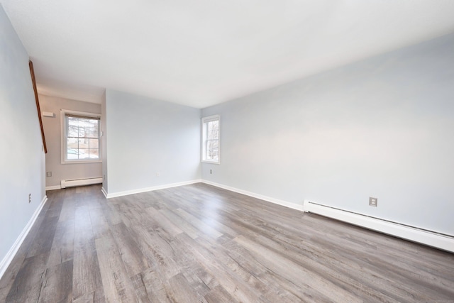 empty room with a baseboard radiator and hardwood / wood-style flooring