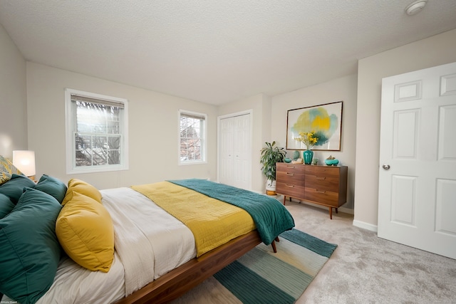 carpeted bedroom featuring a textured ceiling and a closet