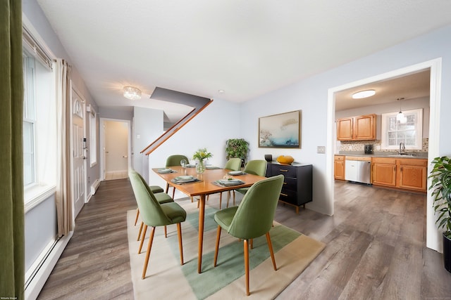 dining space with dark hardwood / wood-style flooring, a baseboard radiator, and sink