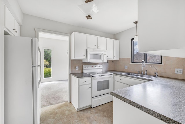 kitchen featuring decorative backsplash, white cabinetry, sink, and white appliances