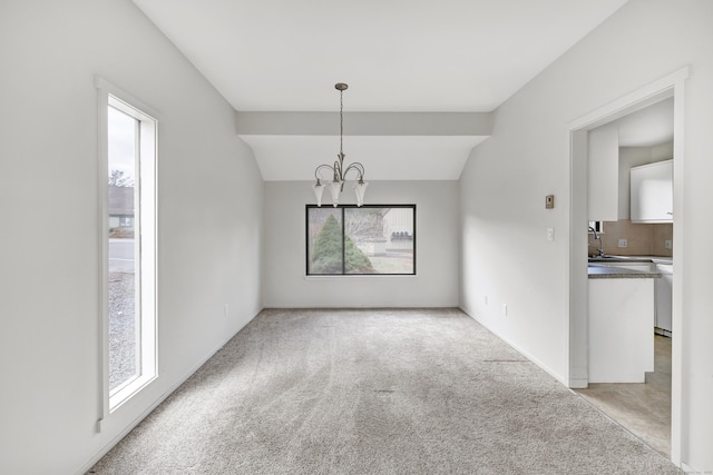 unfurnished dining area featuring plenty of natural light, lofted ceiling, light carpet, and an inviting chandelier