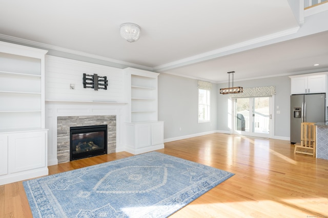 living room with crown molding, light hardwood / wood-style flooring, and a notable chandelier