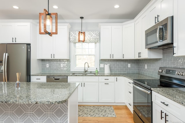 kitchen with sink, white cabinetry, stainless steel appliances, and hanging light fixtures