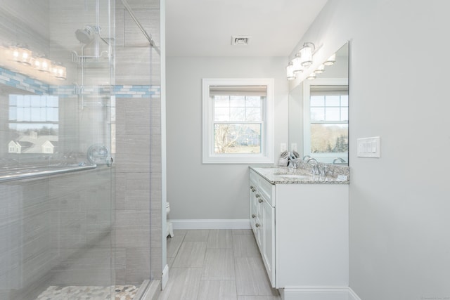 bathroom with vanity and a shower with door