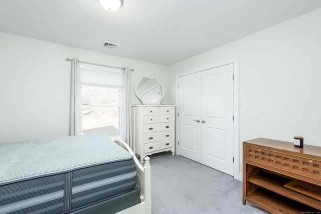 bedroom with light colored carpet and a closet