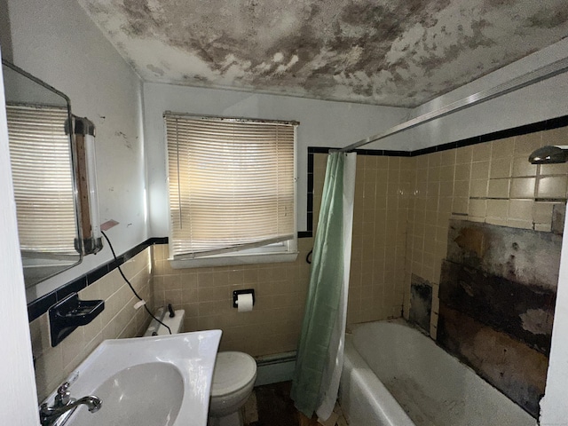 full bathroom with shower / bath combination with curtain, toilet, tile walls, a baseboard heating unit, and sink