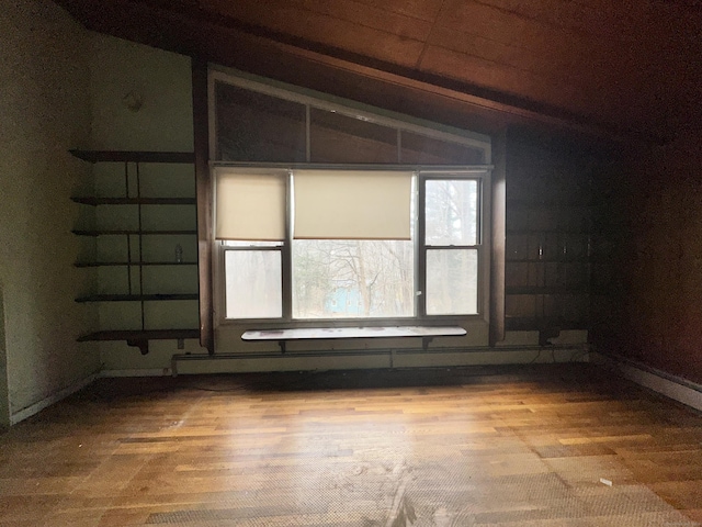 spare room with vaulted ceiling and wood-type flooring