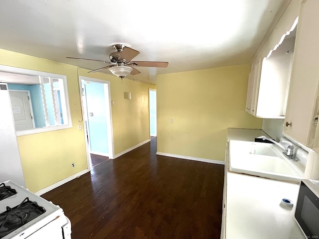 kitchen featuring dark wood-type flooring, white cabinets, sink, ceiling fan, and white range with gas cooktop