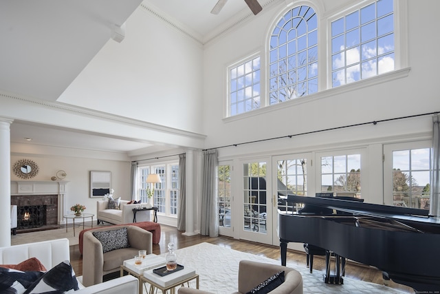 living area featuring crown molding, ceiling fan, french doors, hardwood / wood-style flooring, and a high ceiling