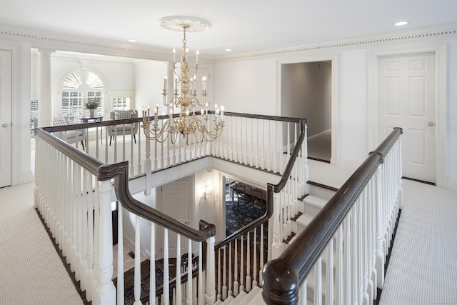 stairs featuring a chandelier, carpet, and ornamental molding