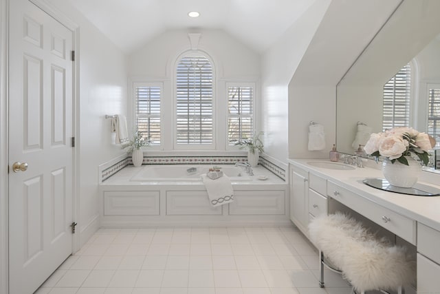 bathroom featuring a tub, tile patterned flooring, lofted ceiling, and vanity