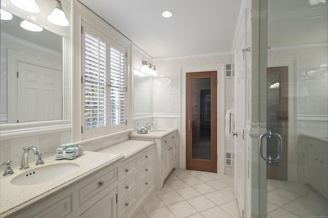 bathroom featuring a shower with door, crown molding, vanity, and tile patterned flooring