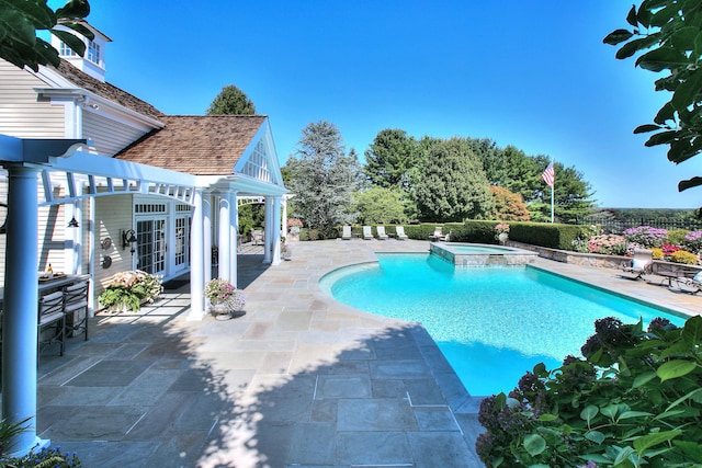 view of swimming pool with an in ground hot tub, a patio area, and an outbuilding