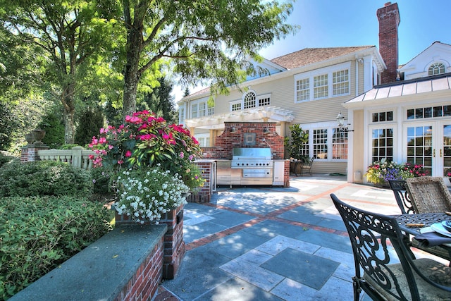 view of patio / terrace with a grill, an outdoor kitchen, and a pergola