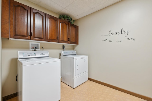 laundry area featuring washing machine and clothes dryer and cabinets