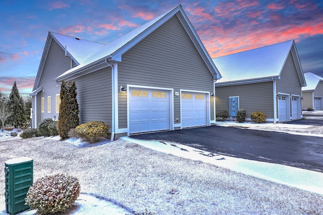 property exterior at dusk featuring a garage