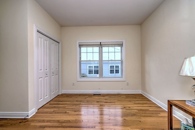 unfurnished bedroom with light hardwood / wood-style floors and a closet